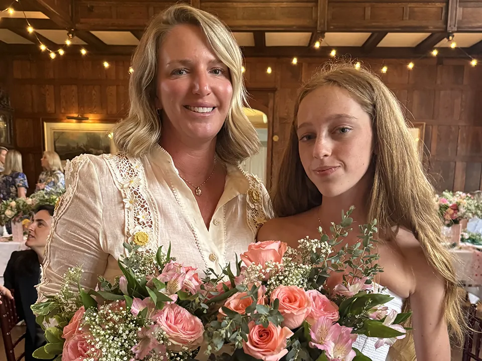 Megan Walsh and her daughter Tenley holding bouquets at Smile Farms Sips & Stems.