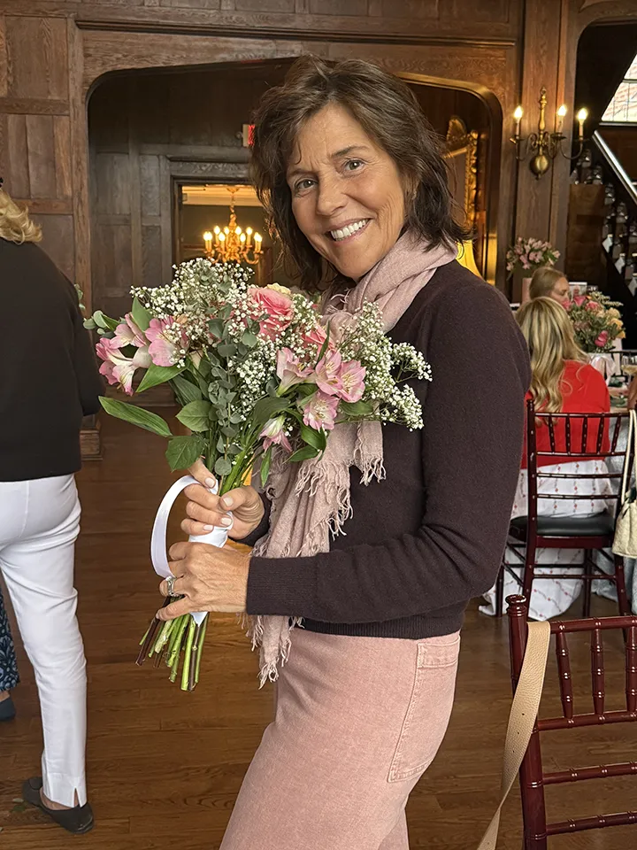 Gail Wagner holding her floral arrangement at Smile Farms Sips & Stems.