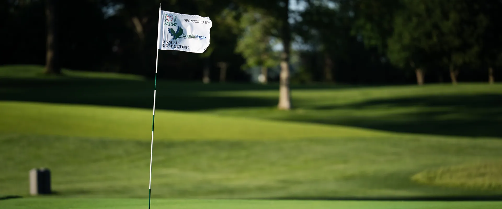 Smile Farms Annual Golf Outing flag on the golf course.